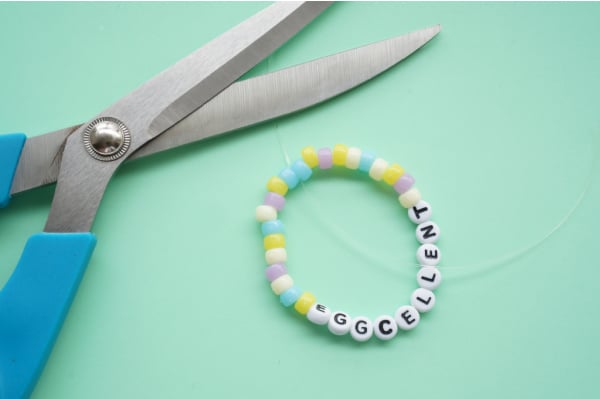 trim the easter bracelet craft with scissors on table
