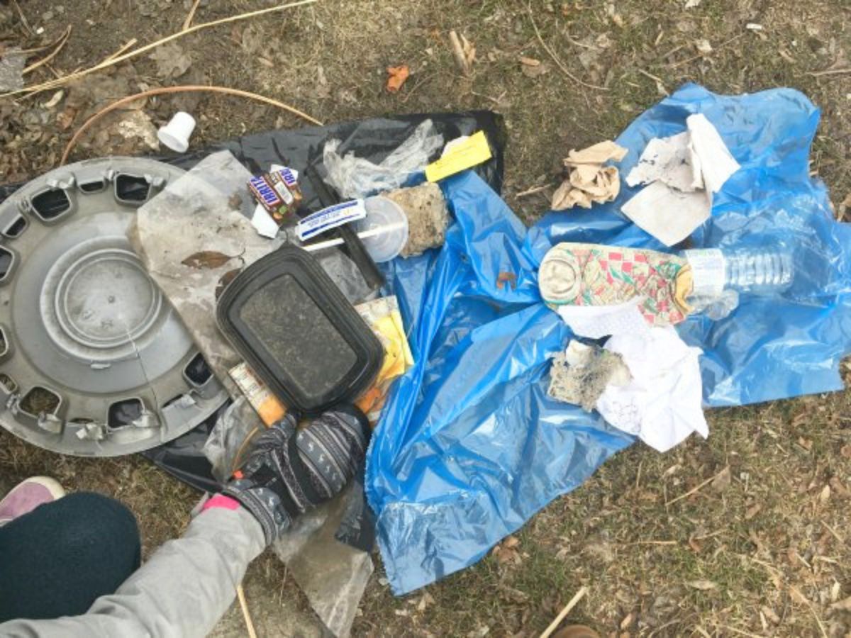 garbage on the lawn with child's hand