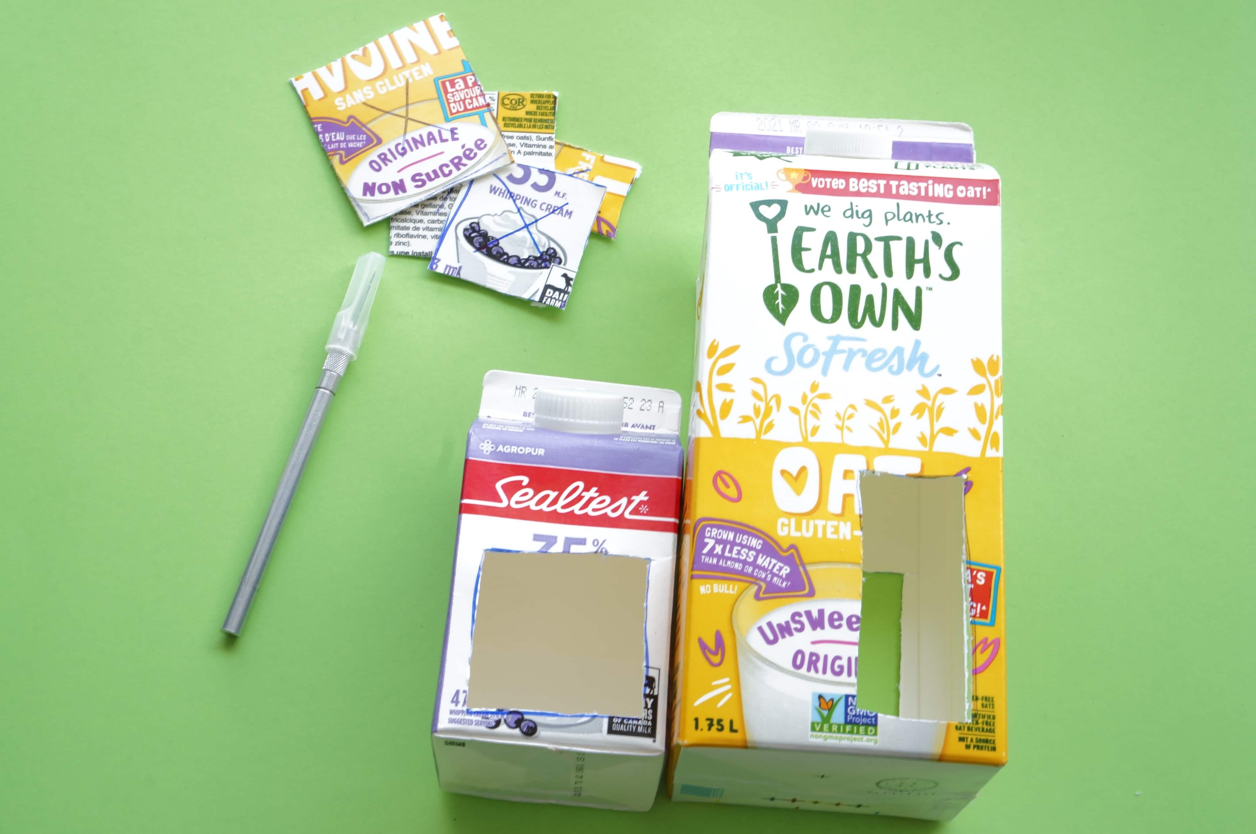 milk cartons with utility knife and openings cut out for bird feeder diy