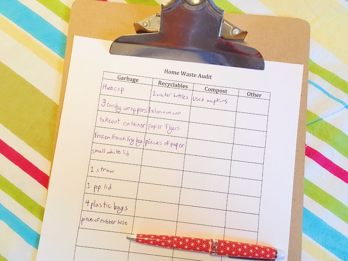 print out of waste audit that has been filled out by kid with a pen on the clipboard