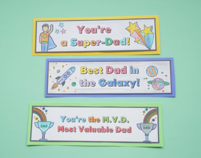 3 colouring fathers day bookmarks done on table