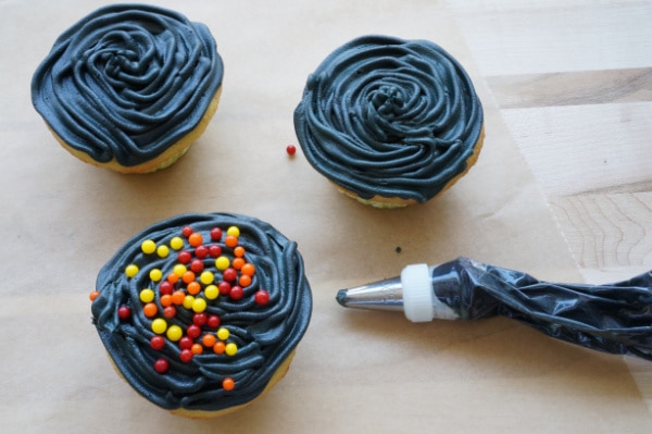 bbq grill cupcakes with black icing and red orange and yellow candy balls on top