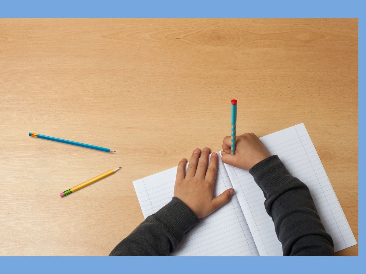 kid writing in a lined notebook