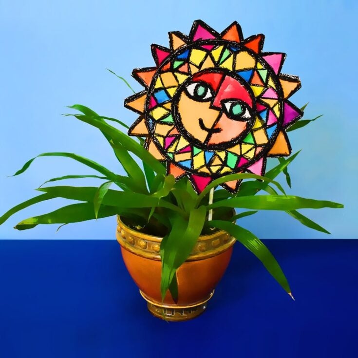 spinning sun pinwheel art poked into plant pot