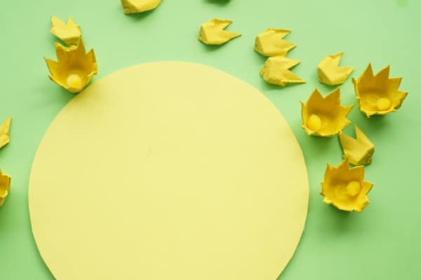 yellow bristol board circle with yellow egg carton flowers