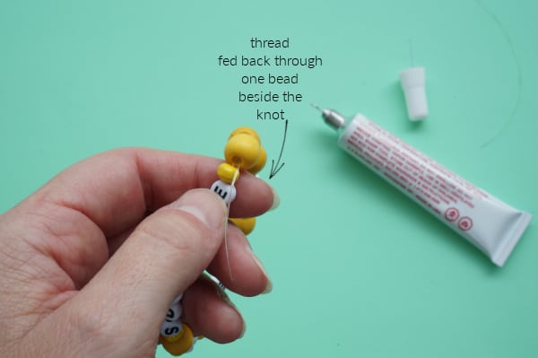 bracelet thread fed back through the bead beside the knot
