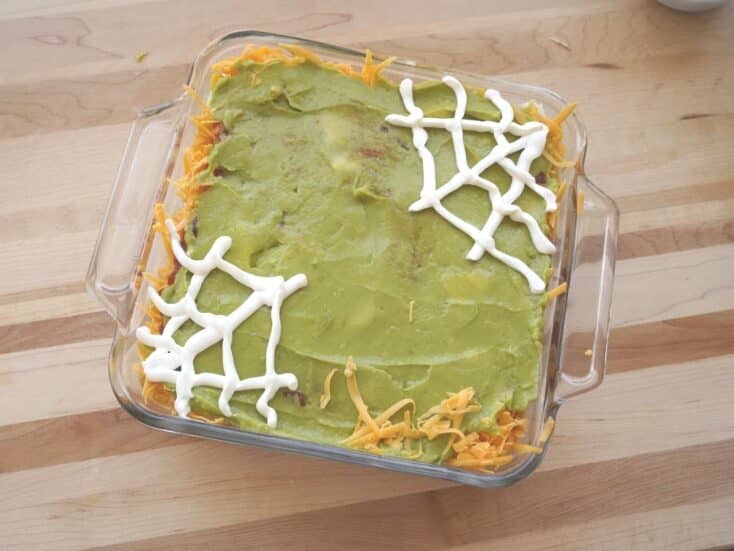 7 layer dip with sour cream spider webs on top