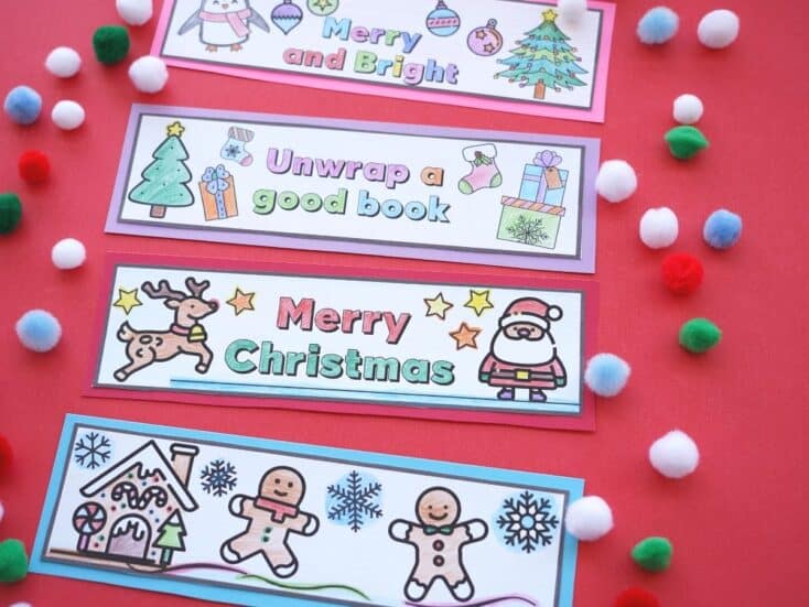 christmas bookmarks printed out and coloured with a pile of pom poms