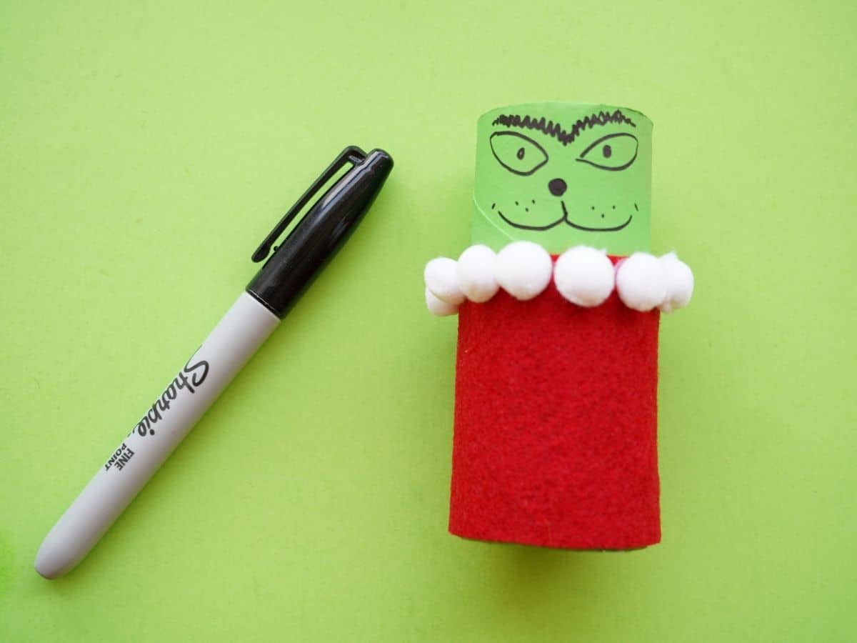 grinch face drawn on toilet paper roll grinch