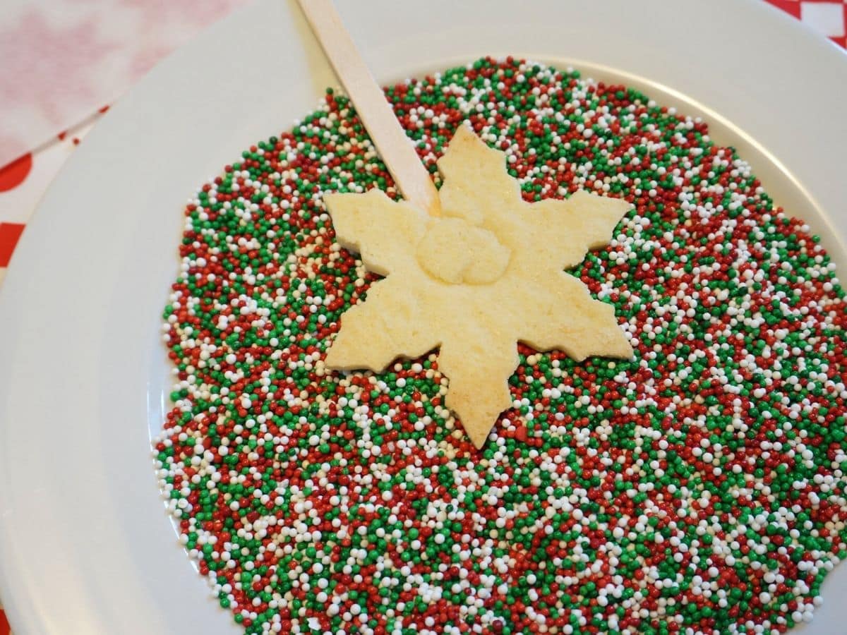 snowflake christmas cookie pop dipped in christmas sprinkles