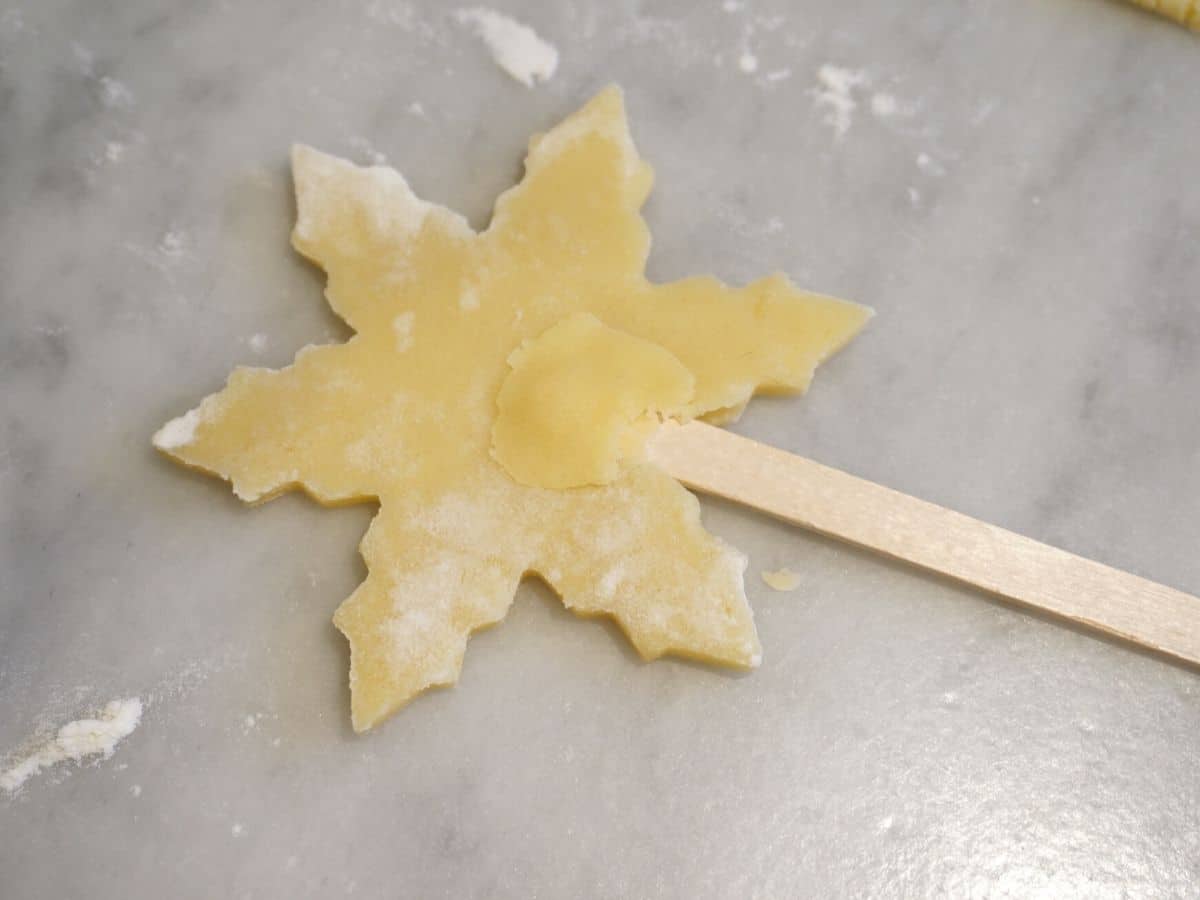 snowflake christmas sugar cookie pop dough pressed into popsicle sticks