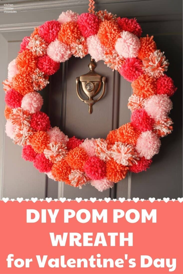 diy valentines pom pom wreath hanging on door