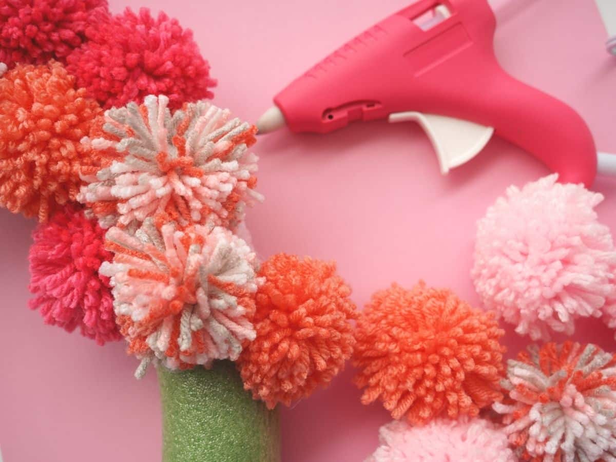 valentine pom pom glued to wreath form with glue gun