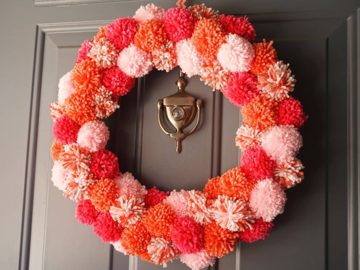 diy pom pom wreath on the door for Valentine's Day