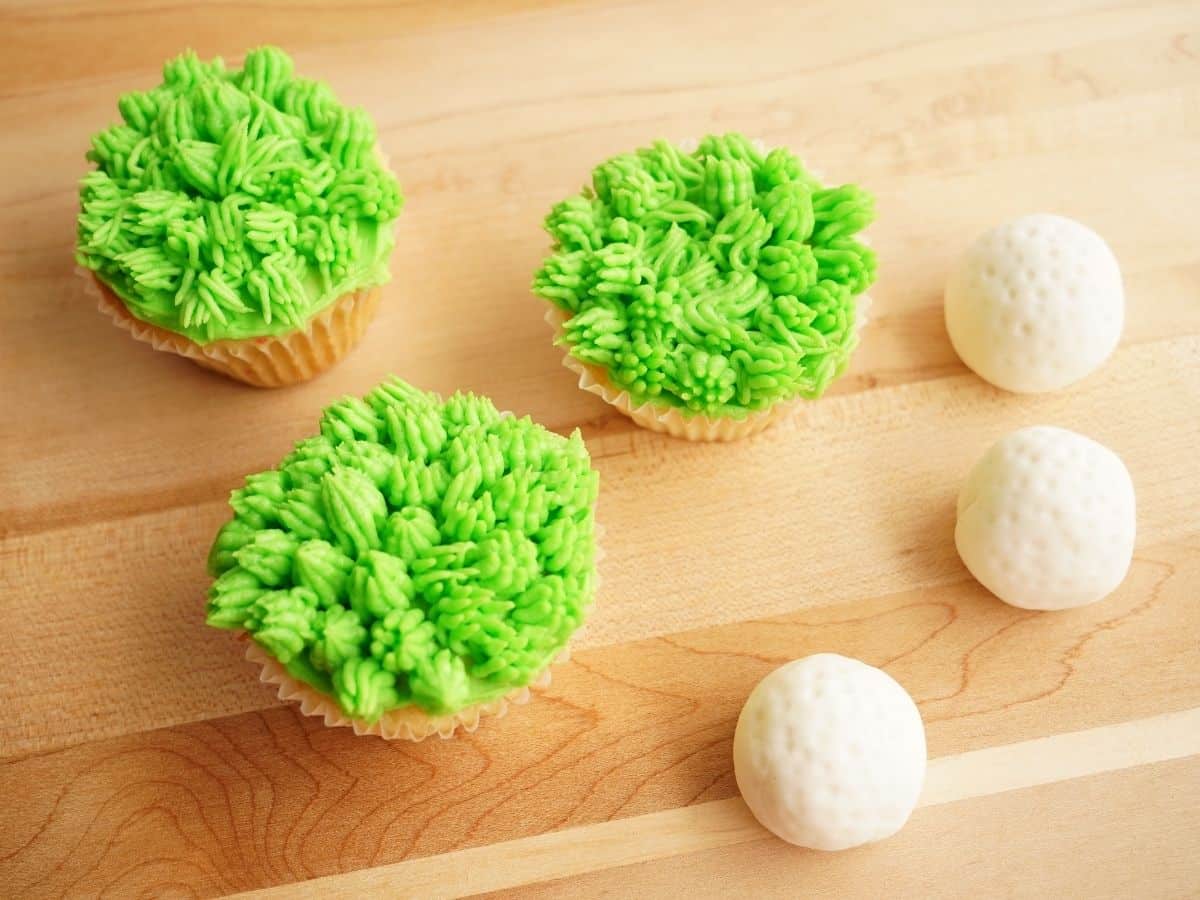 2 fathers day golf cupcakes with grass frosting and fondant golf balls