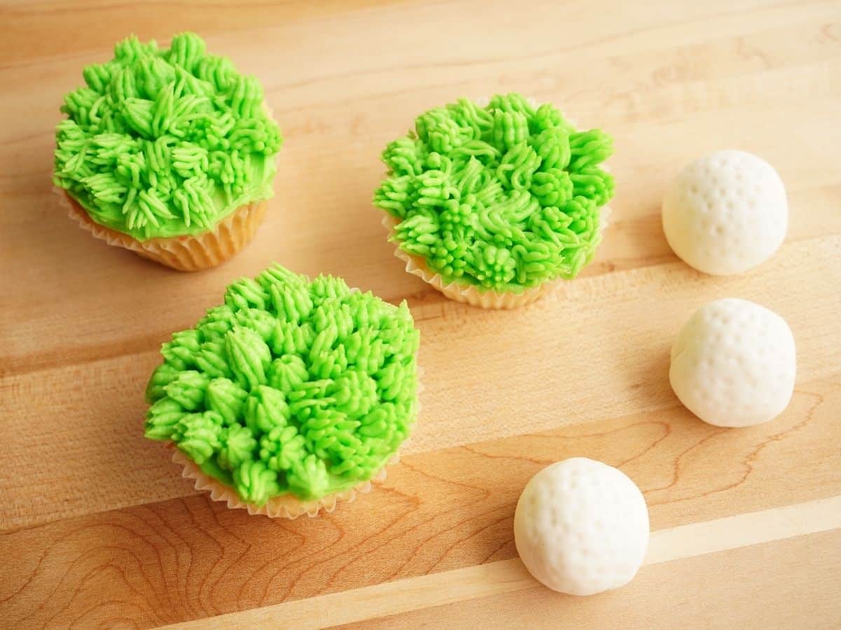 2 fathers day golf cupcakes with grass frosting and fondant golf balls