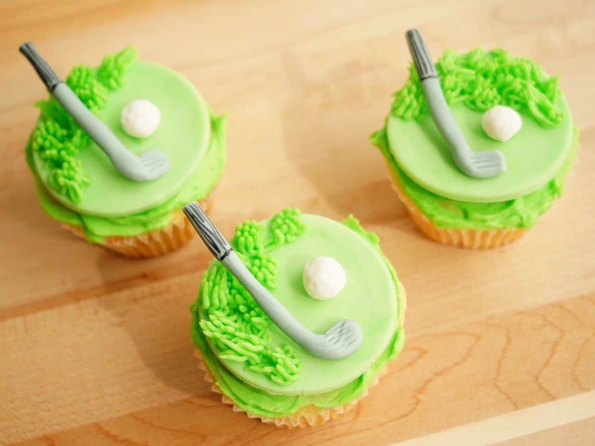 3 golf green cupcakes with fondant golf clubs and fondant golf balls