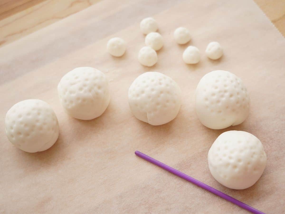 big fondant golf balls stuffed with peanut butter cups and little fondant golf balls with paintbrush