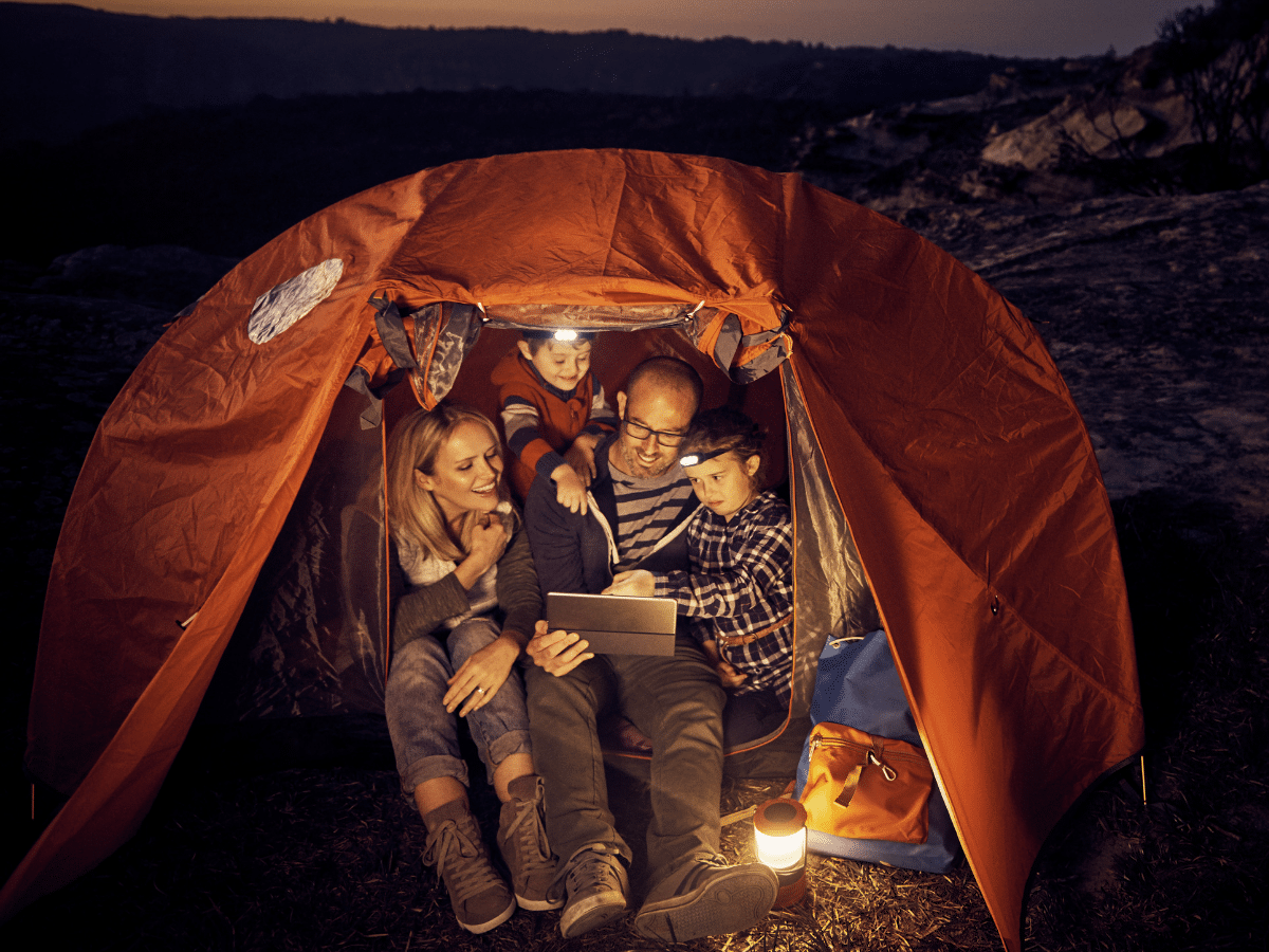 family watching a summer movie in a tent