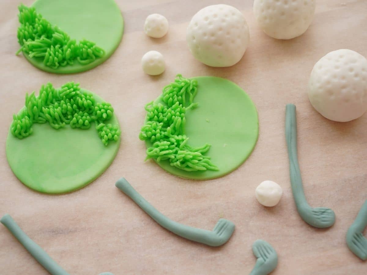 green buttercream frosting to make grass on the green fondant disks golf clubs and golf balls