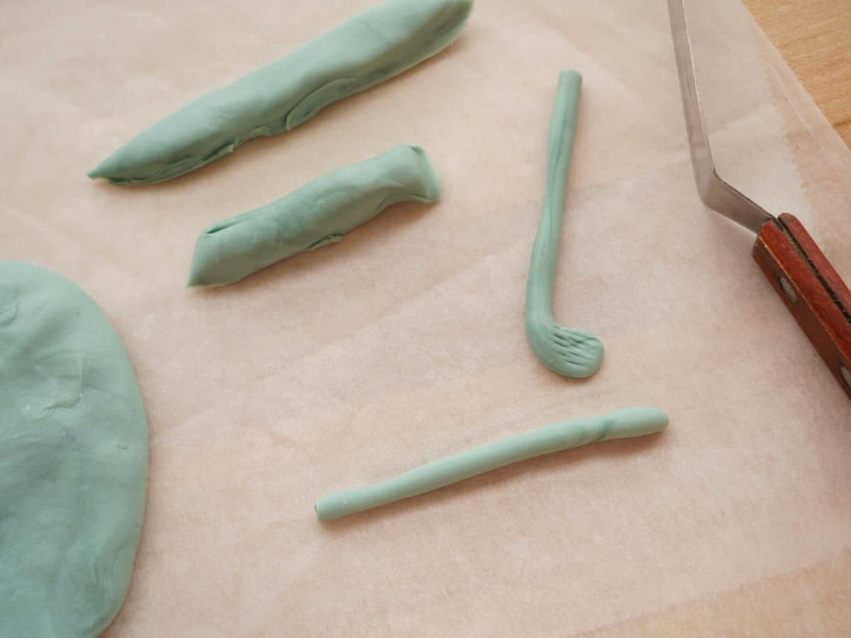grey fondant rolled into snakes and golf club shapes