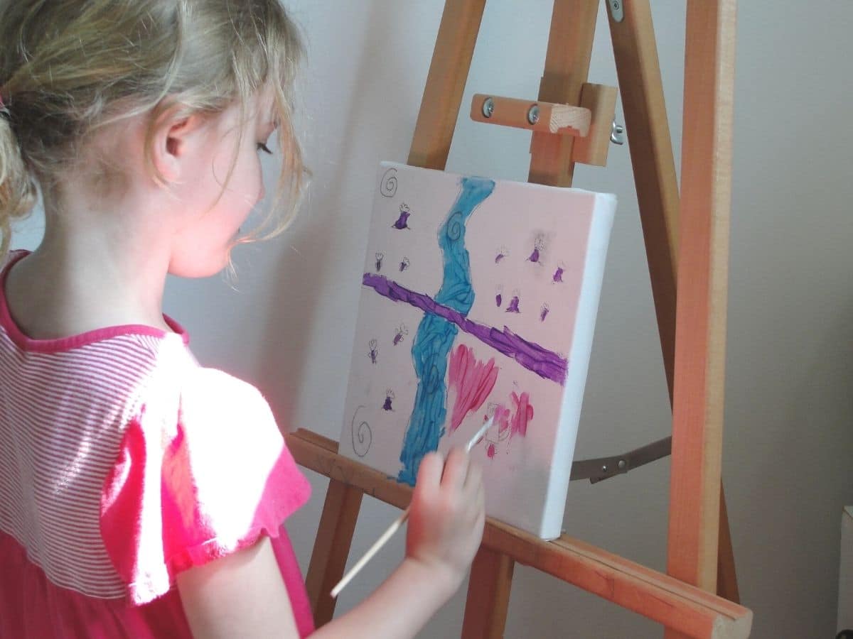 kid painting on an canvas at an easel rodrigue painting