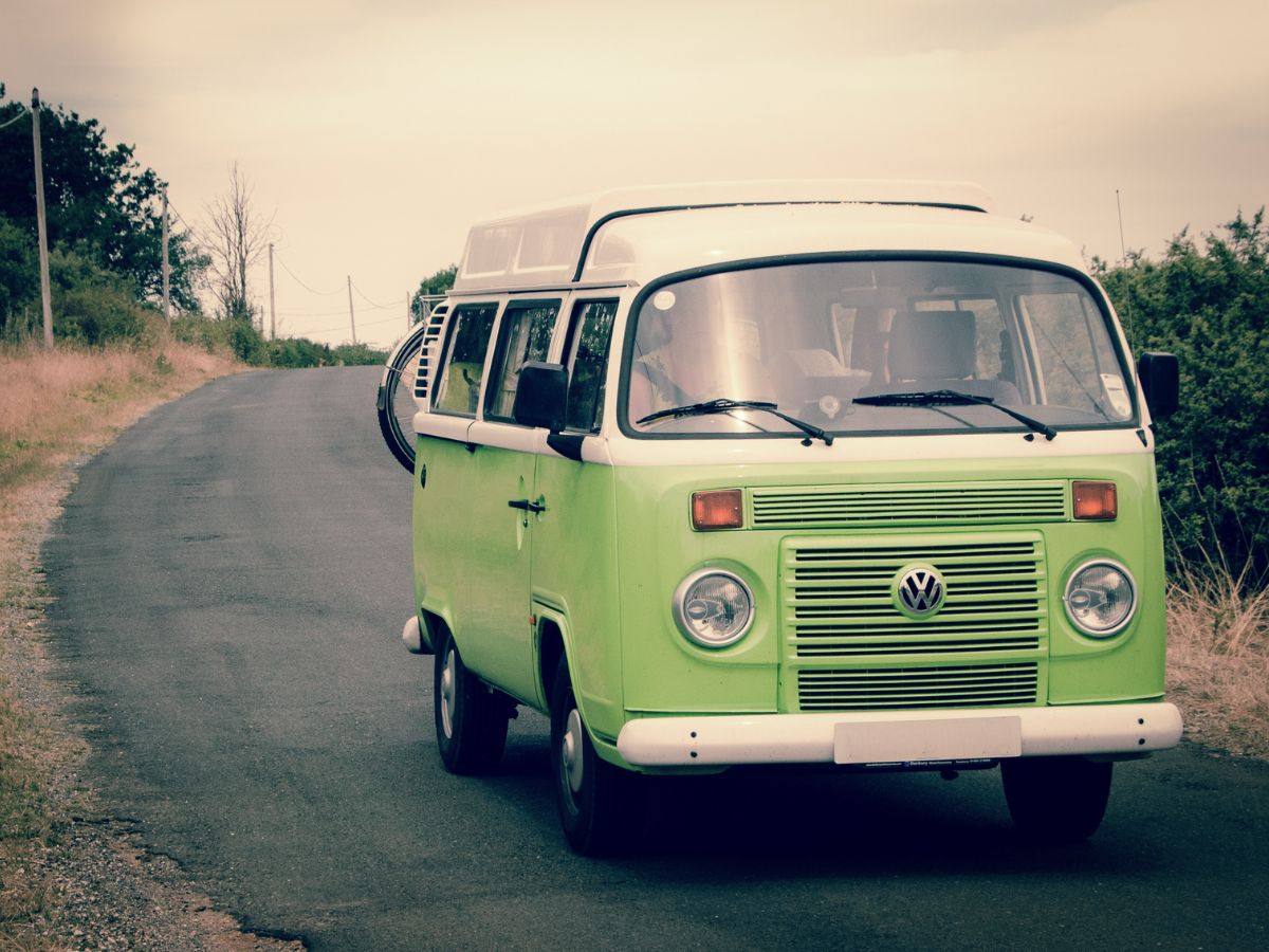 green volkswagon camper van driving on the road