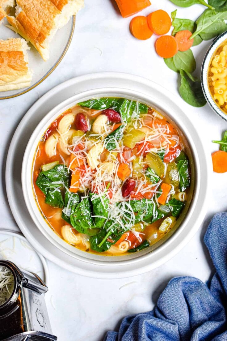 bowl of spinach and pasta soup with parmesan sprinkled on top
