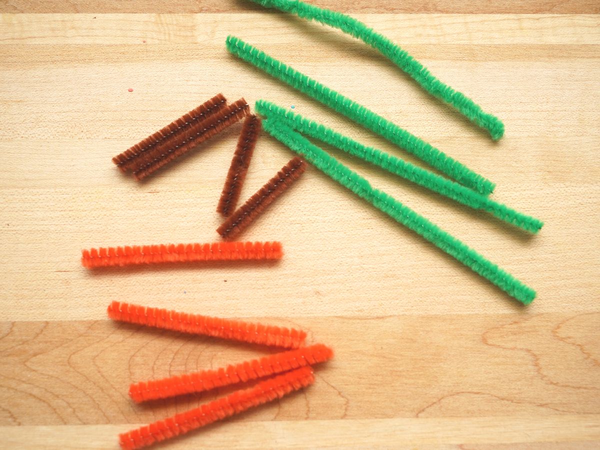 orange, green and brown pipe cleaners cut to size for the egg carton jack olantern treat boxes