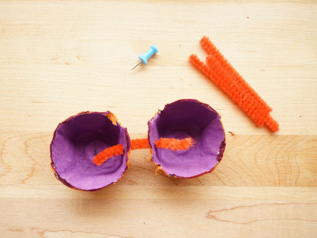 orange pipe cleaner poked in both egg carton pumpkin pieces