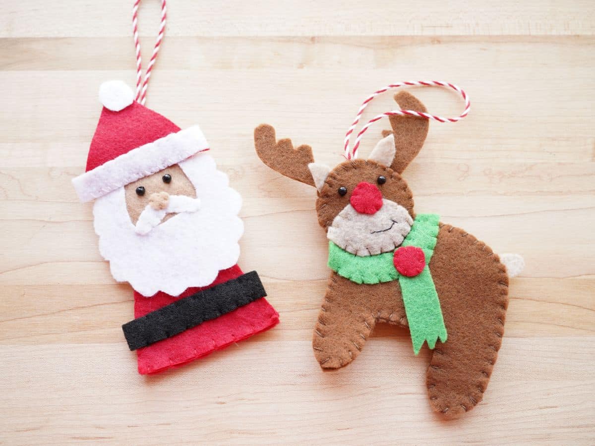 felt santa ornament and felt reindeer ornament side by side on wooden table
