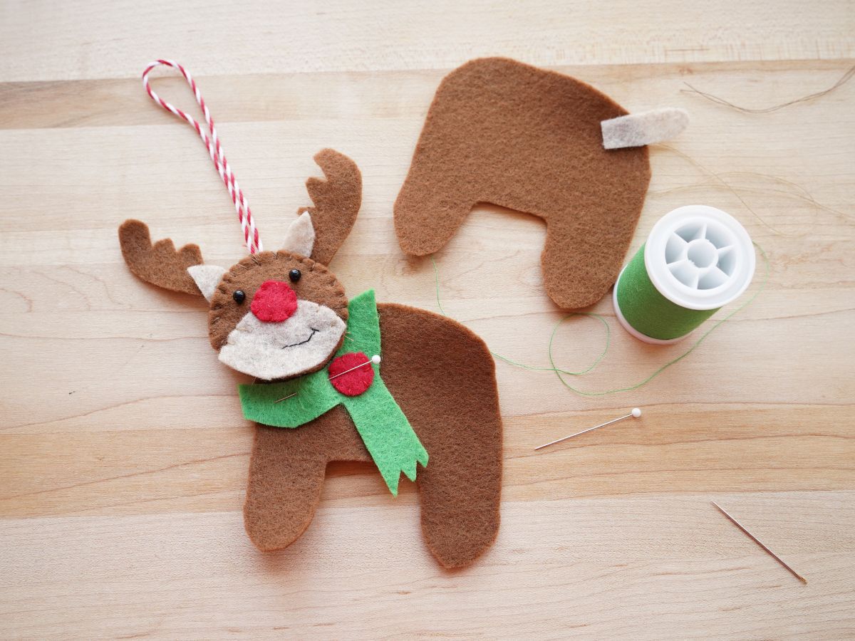 felt rudolph ornament with head done and pins in scarf and green spool of thread