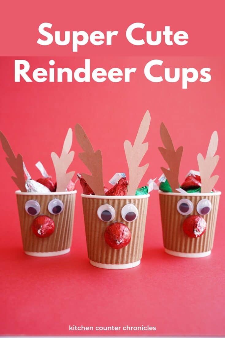 3 reindeer cups filled with chocolate kisses with title