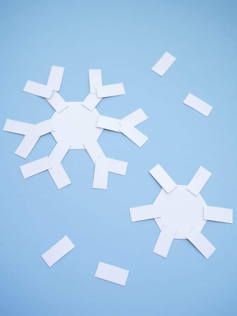 winter stem project 2 paper snowflakes forming on blue background