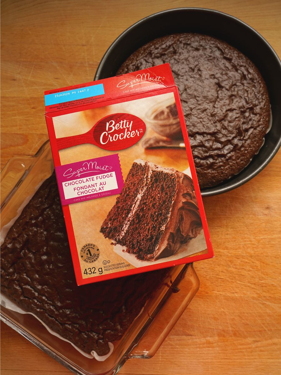 betty crocker cake mix box over round chocolate cake in pan and square  chocolate cake in pan