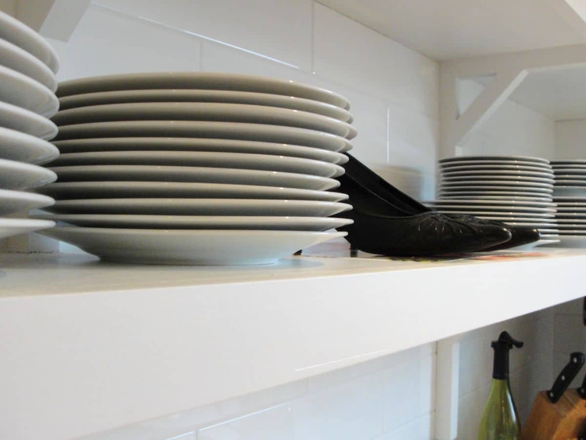 shelf with dishes and a pair of shoes on it