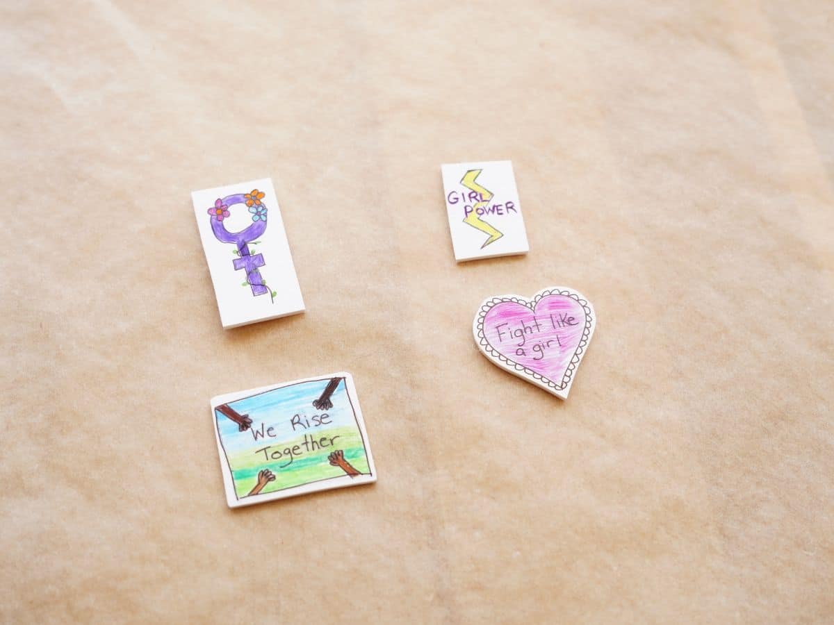 shrinky dink women's history month pins out of the oven on parchment paper