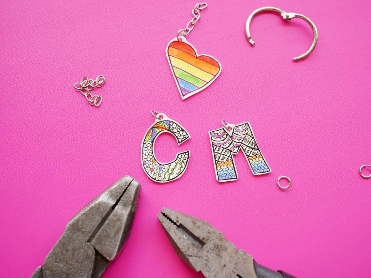 letter c, letter m and heart zentangle keychains shrunk down with jump rings through holes and 2 pairs of pliers