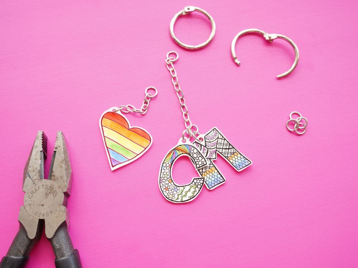 letter c, letter m shrinky dink keychains with chain together and key ring and pair of pliers