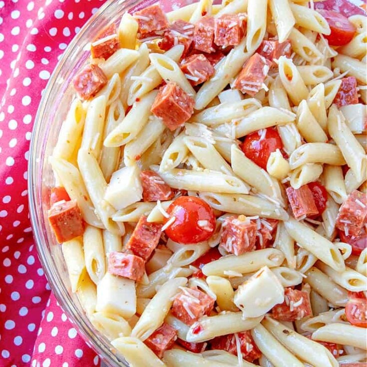 close up of pizza pasta salad with chunks of pepperoni, mozzarella and tomatoe