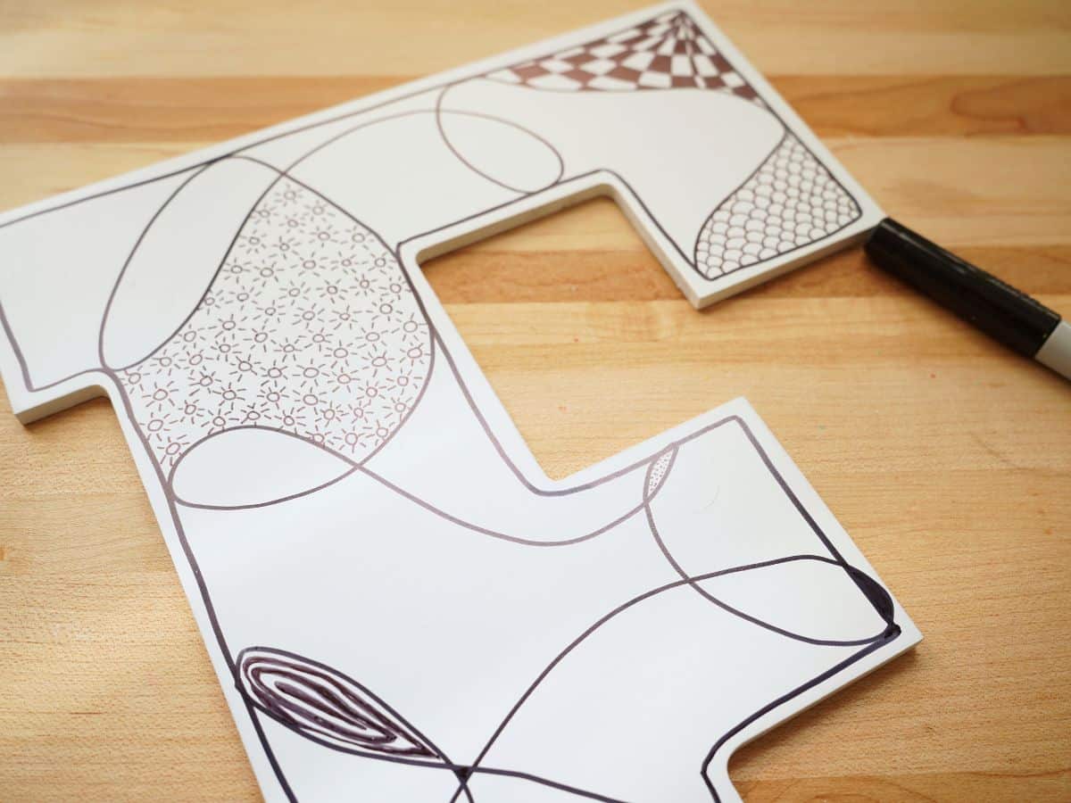 close up of sun zentangle pattern on wooden wall art project with marker