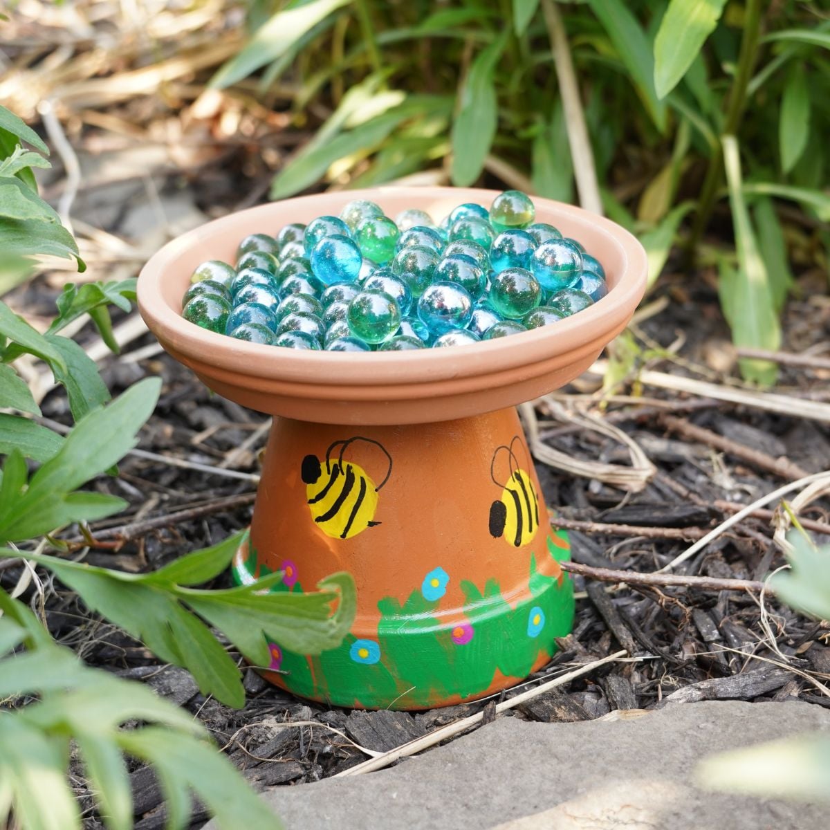 diy terra cotta pot bee bath with marbles in the garden featured image
