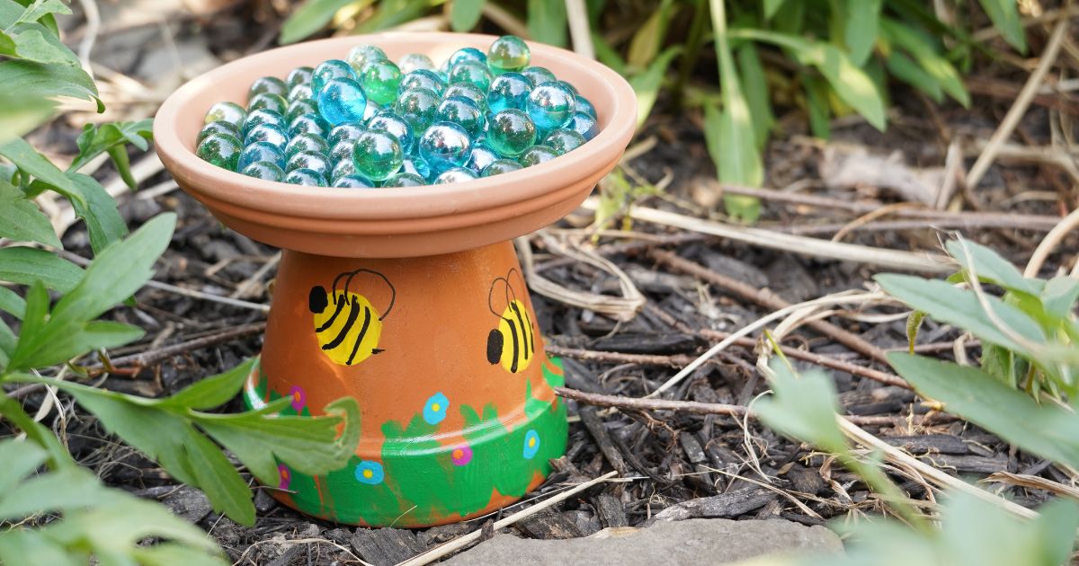 diy terra cotta pot bee bath with marbles in the garden social image