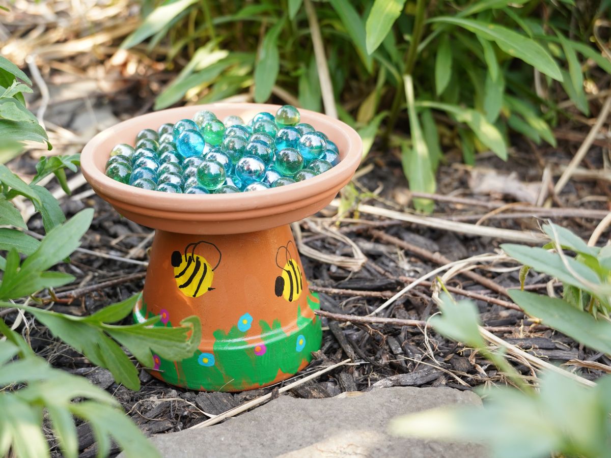 diy terra cotta pot bee bath with marbles in the garden