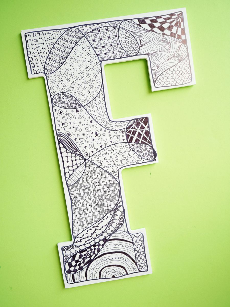 final zentangle wall art project for tweens and teens initial with zentangle patterns inside and hung on green wall