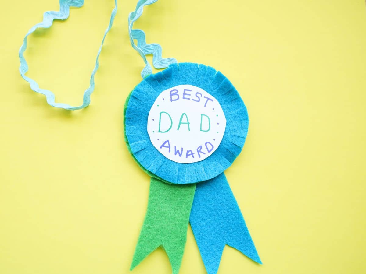 fully assembled father's day medal craft made from felt with yellow background