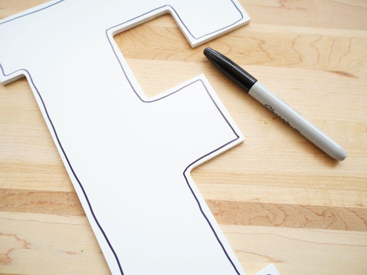 sharpie marker line drawn around edge of white wooden letter f