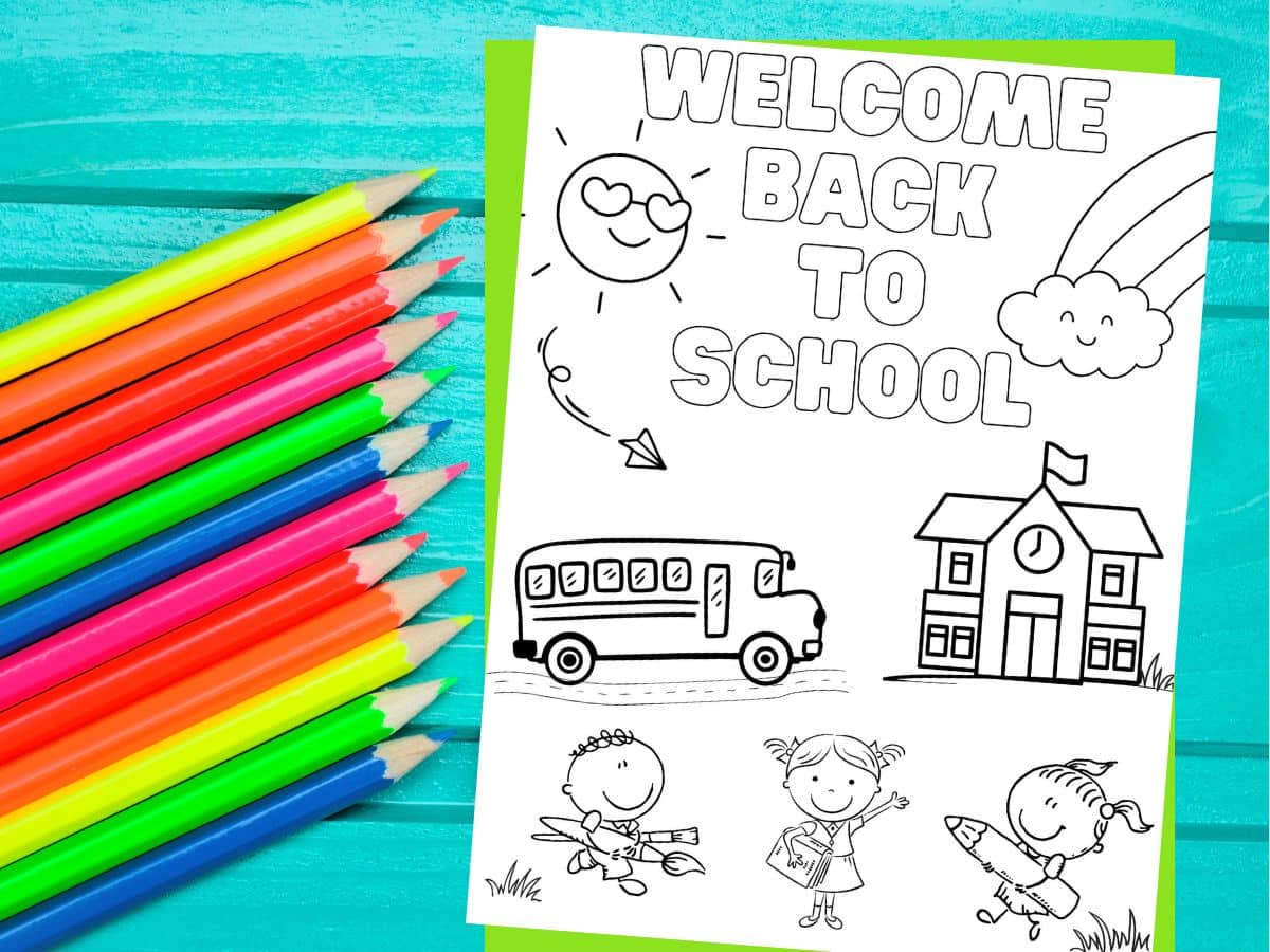 welcome back to school coloring page with school bus, school and students, printed on desktop with pencil crayons