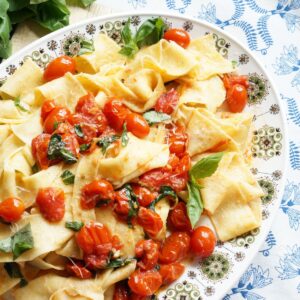 platter of homemade pappardelle with cherry tomato sauce on plate
