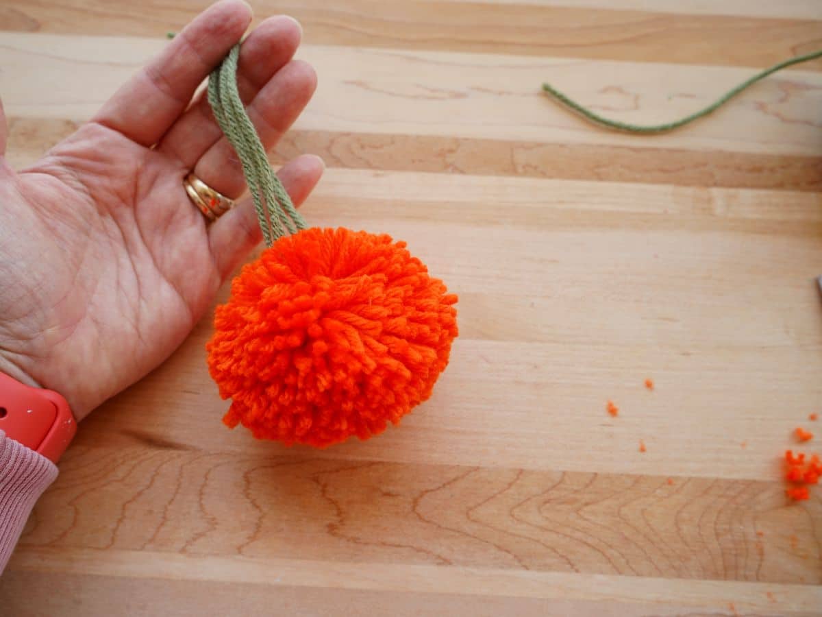 finished pom pom pumpkin in woman's hand